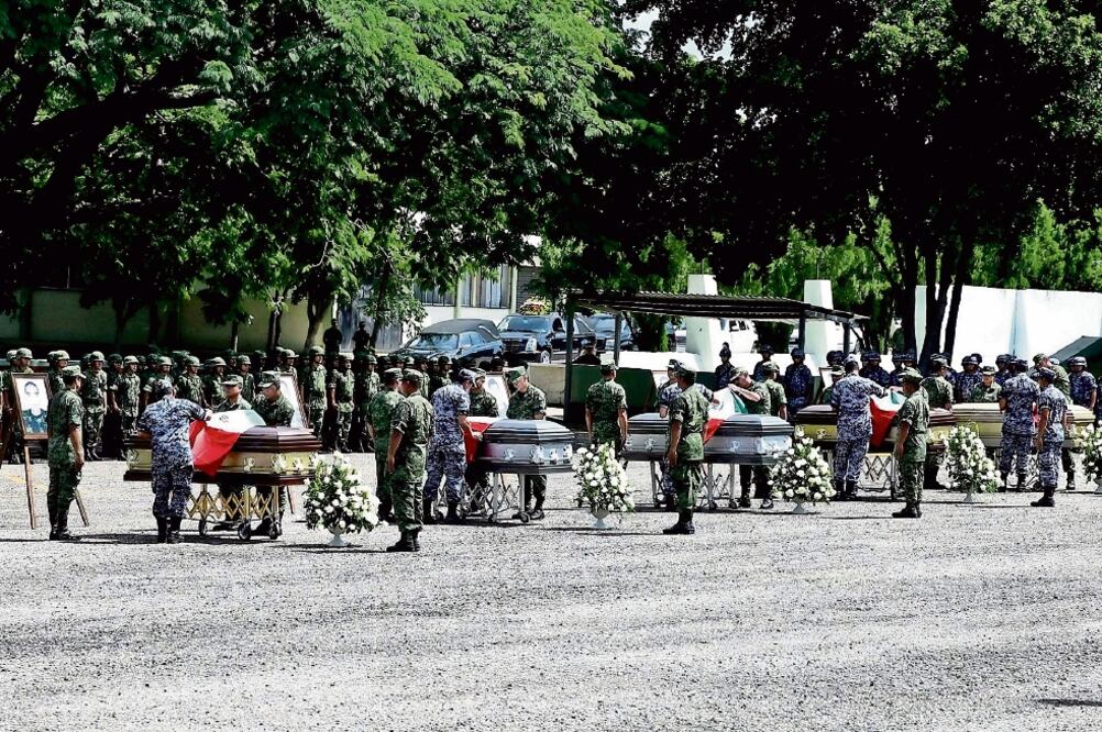 En el 94 Batallón de Infantería colocaron los cinco féretros, formados uno a lado de otro, con las fotografías de quienes fallecieron (CUARTOSCURO)