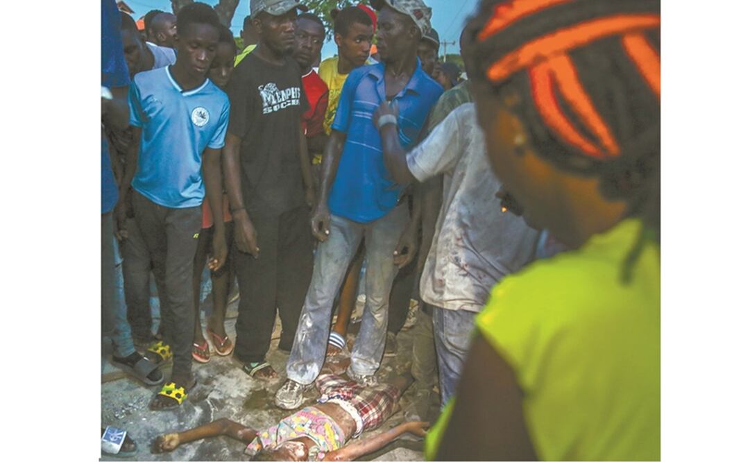 Habitantes, alrededor de una víctima, tras el sismo en Haití. Foto: Joseph Odelyn. AP