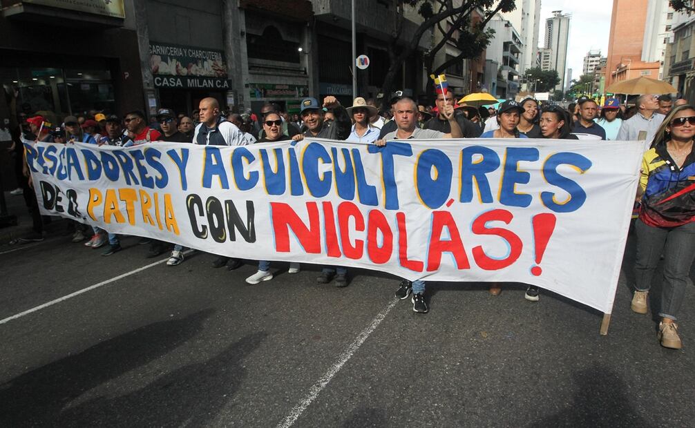 Los simpatizantes del oficialismo, algunos de ellos empleados públicos, marcharon con prendas, pancartas, elementos e imágenes alusivas al chavismo, mientras coreaban consignas a favor del mandatario. Foto: EFE/ Manuel Díaz