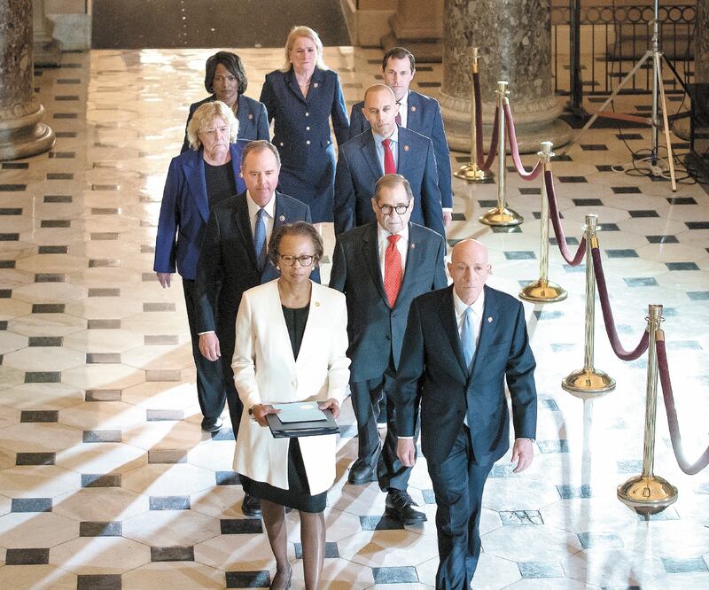 Cheryl Johnson, secretaria jurídica de la Cámara Baja, con Paul Irving, sargento de armas, y los siete “gesto res” en el juicio político contra el mandatario Donald Trump, ayer en el Capitolio en Washington. J. SCOTT APPLEWHITE. AP
