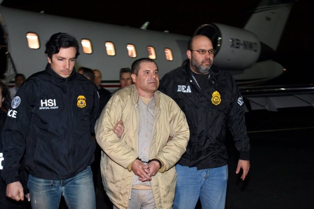 In this photo provided U.S. law enforcement, authorities escort Joaquin "El Chapo" Guzman, center, from a plane to a waiting caravan of SUVs at Long Island MacArthur Airport on Thursday, Jan. 19, 2017, in Ronkonkoma, N.Y.  (U.S. law enforcement via AP)