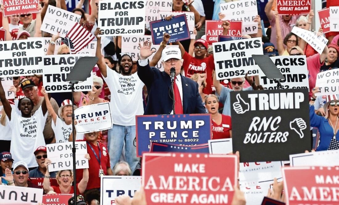 El candidato republicano, Donald Trump, encabezó ayer un evento en Florida rodeado de pancartas de “Mujeres con Trump” y “Negros con Trump” (EVAN VUCCI.AP)