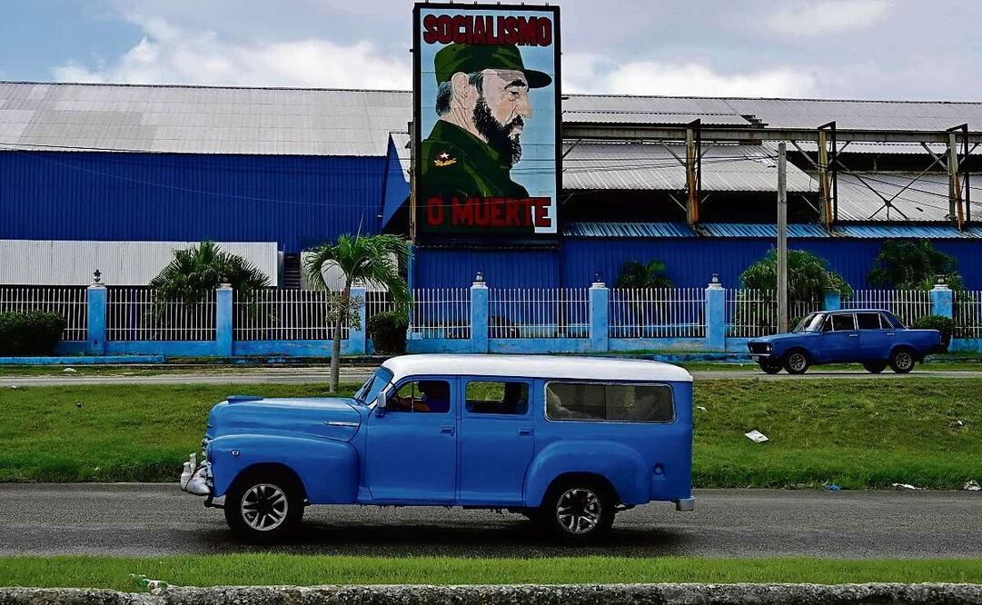 Autos antiguos, junto a una valla publicitaria en La Habana, el lunes pasado. Foto by Yamil Lage / AFP
