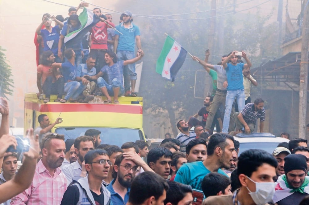Decenas de personas se manifestaron ayer en Aleppo. Quemaron llantas para provocar humo el cual, aseguran, los protege de los ataques aéreos (ABDALRHMAN ISMAIL. REUTERS)