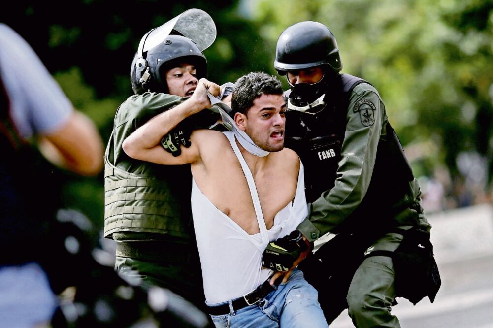Policías detienen a un manifestante, durante la última jornada de paro cívico convocado por la oposición en rechazo de la elección para la Asamblea Constituyente que tendrá lugar este domingo en Venezuela. (UESLEI MARCELINO. REUTERS)