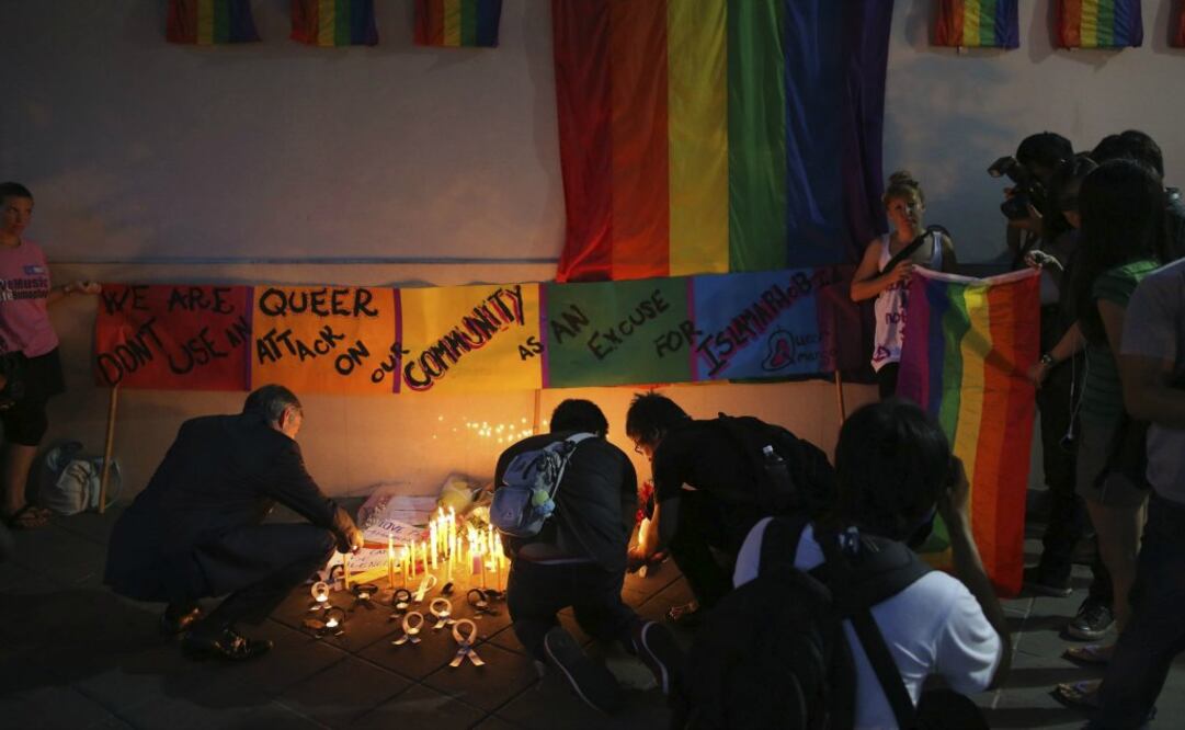 Varias personas encienden velas en memoria de las victimas del ataque en la discoteca gay en Orlando, en las puertas de la embajada estadounidense en Bangkok, Tailandia. Foto: EFE