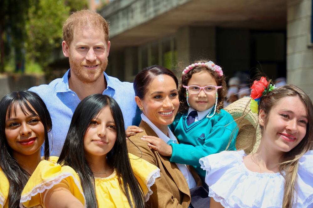 El príncipe Harry junto a su esposa Meghan Markle (centro) y estudiantes de la escuela La Giralda en Bogotá el 16 de agosto de 2024. Foto: AFP