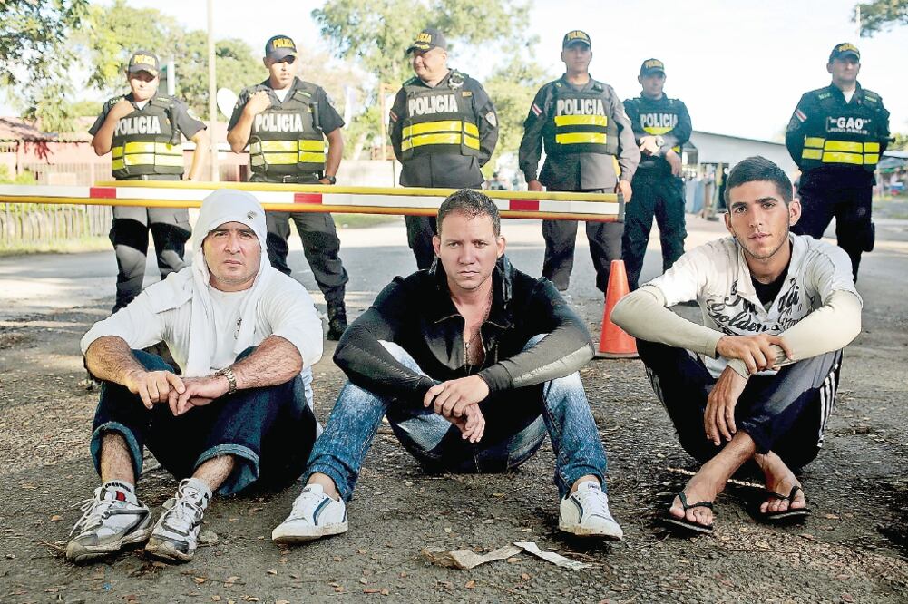 A manera de protesta, migrantes cubanos se sientan frente a policías mientras esperan les abran la frontera nicaragüense, en Peñas Blancas, Costa Rica (OSWALDO RIVAS. REUTERS)