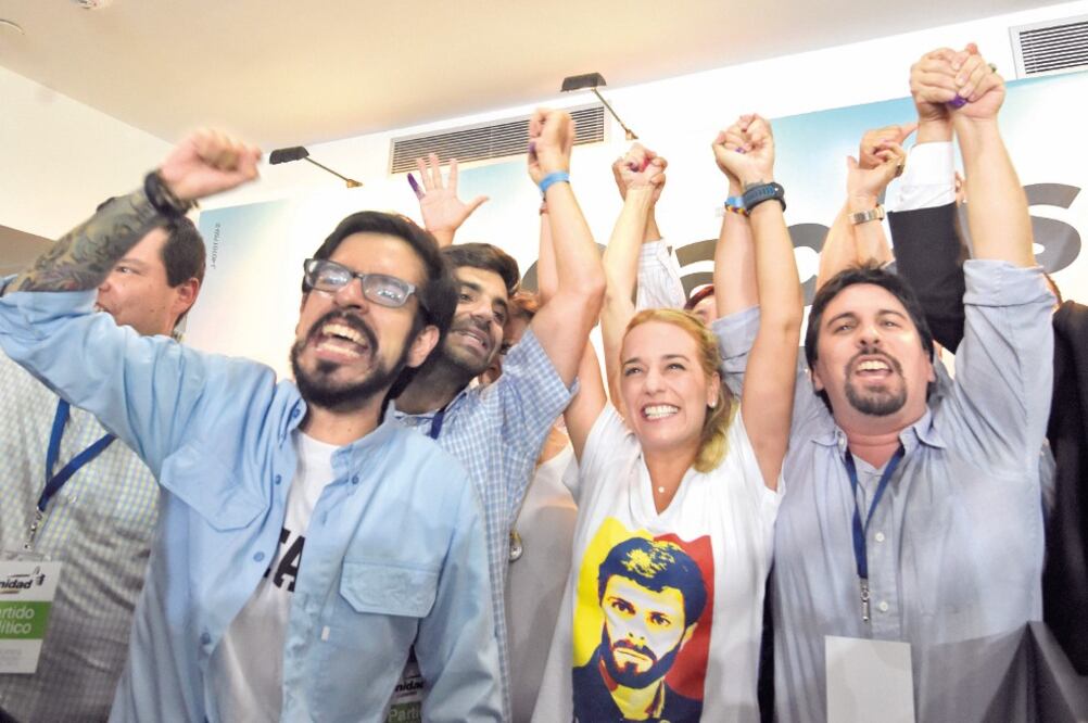Lilian Tintori (centro), esposa del líder opositor venezolano Leopoldo López, celebra los resultados de los comicios del pasado 6 de diciembre (ARCHIVO AFP)