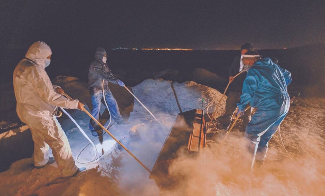 Trabajadores funerarios entierran un féretro en un cementerio para personas de bajos ingresos, en Perú. Foto: Diego Ramos. AFP