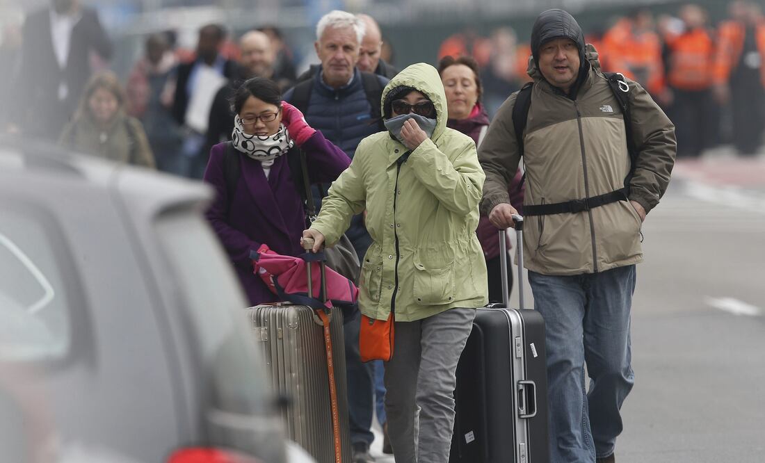Varios pasajeros evacúan el edificio de la terminal tras registrarse explosiones en el aeropuerto internacional de Zaventem, cerca de Bruselas (EFE)