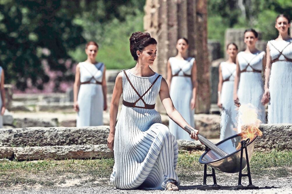 Katerina Lehú, en su papel de gran sacerdotisa de Olimpia, encendió la flama utilizando un espejo parabólico (FOTOS. YANNIS KOLESIDIS. EFE)