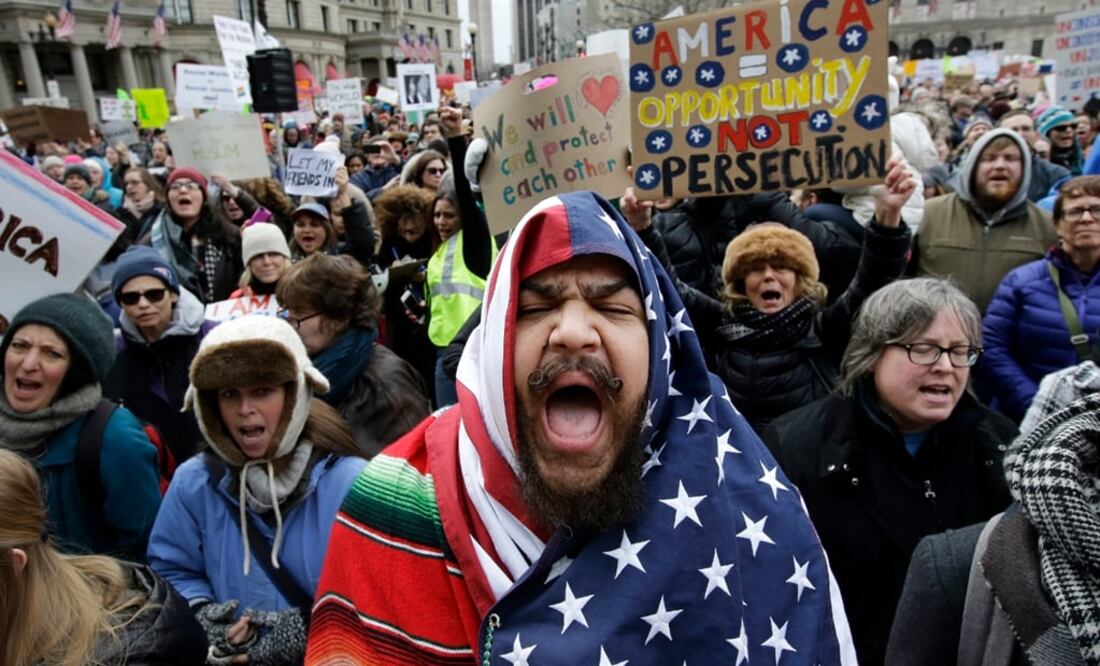 Un hombre envuelto con una bandera estadounidense grita consignas en Boston junto con otros manifestantes contra el decreto del presidente Donald Trump, que consiste en la restricción de ingreso a Estados Unidos a ciudadanos de siete países. Foto: AP