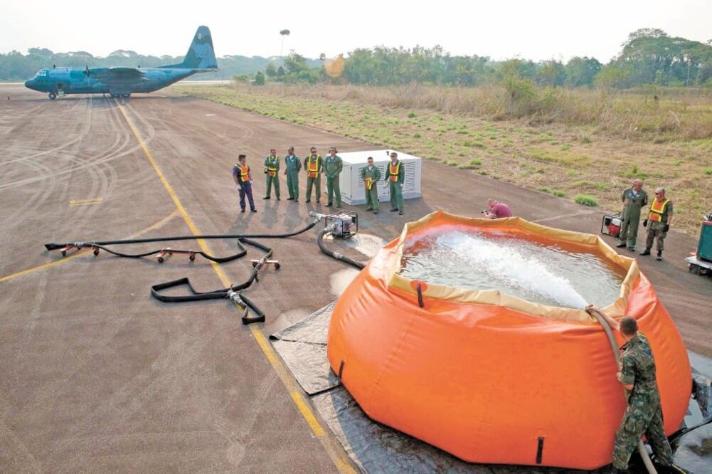 Militares recargaron de agua las bombas que el avión Hércules C-130 de la Fuerza Aérea brasileña suelta en la selva amazónica para apagar los incendios en Rondonia, Brasil. Foto/EFE