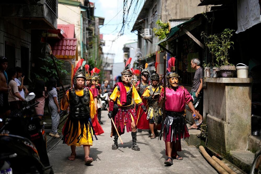 Artistas disfrazados de soldados romanos pasean por la ciudad mientras recrean la pasión y los sufrimientos de Jesucristo como parte de su práctica cuaresmal para conmemorar el Jueves Santo el 17 de abril de 2025 en la ciudad de Paete, provincia de Laguna, Filipinas. FOTO: AARON FAVILA. AP