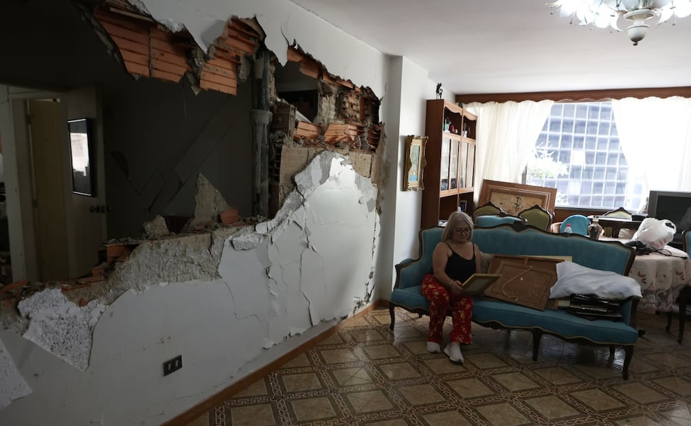 Una venezolana permanece en su vivienda dañada mientras evalúa las pérdidas tras los terremotos en Caracas (26/06/2026). Foto: AP