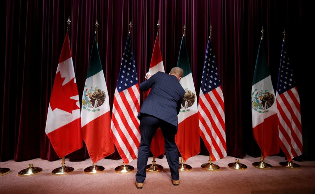 A staff member moves flags - Photo: Chris Wattie/REUTERS
