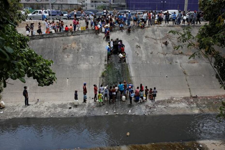 Captan largas filas para recoger agua contaminada en río de Caracas tras apagón