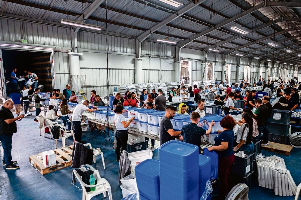 Empleados del Tribunal Electoral Supremo revisan los materiales con miras a la jornada de este domingo, en Ciudad de Guatemala. Foto: AFP