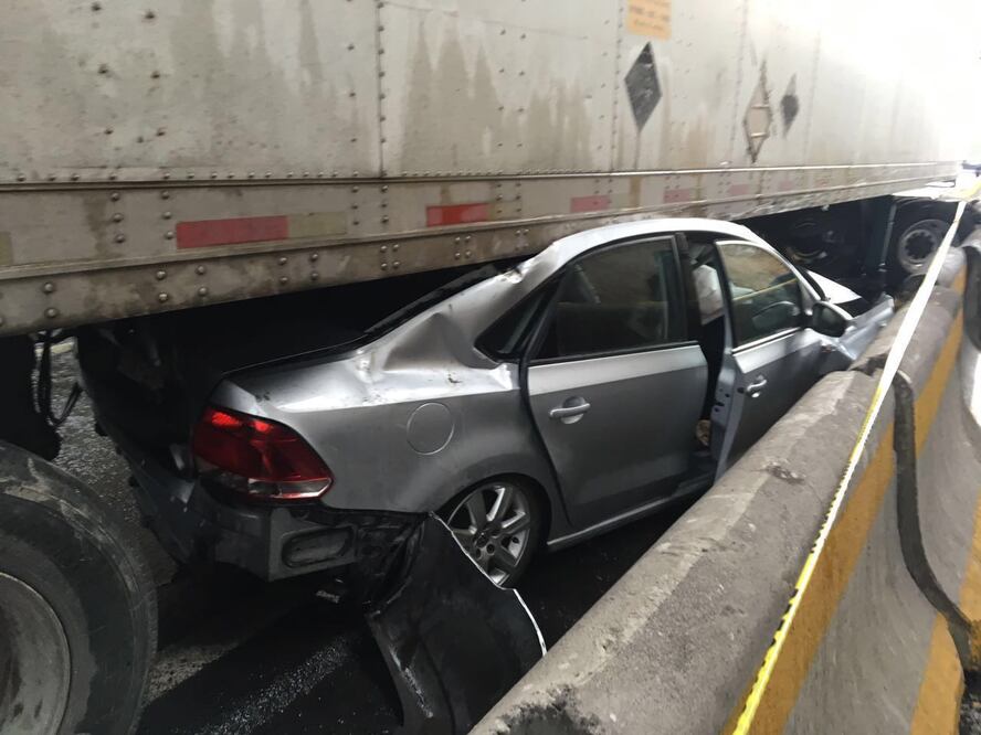 La conductora de un auto compacto sobrevivió al quedar bajo un trailer. FOTO: Especial