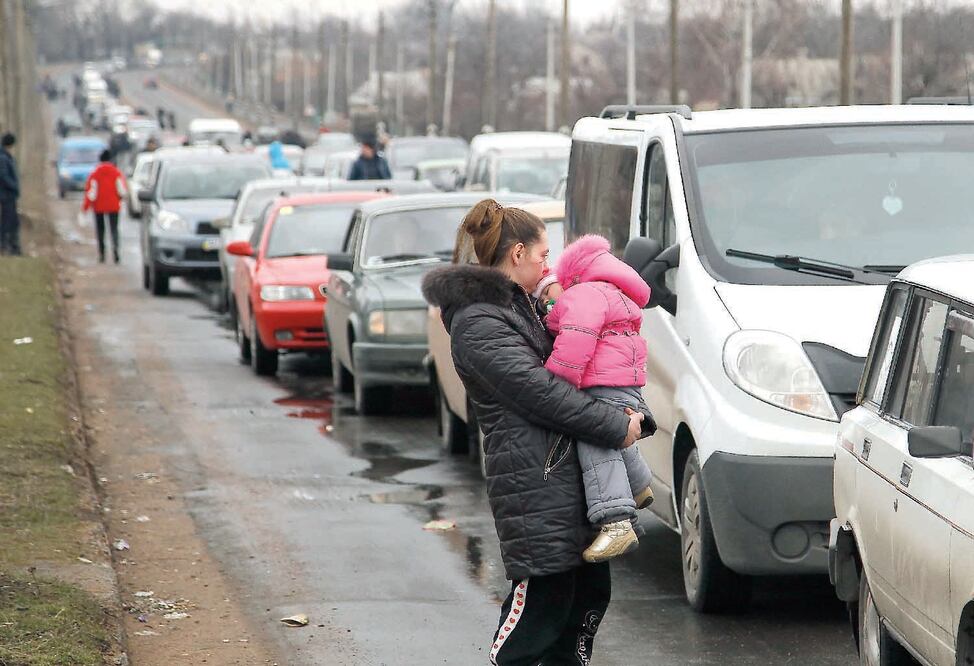 Ucranianos hacen fila para pasar por el punto de registro que les permite cruzar a territorio controlado por rebeldes prorrusos, en Donetsk (ALEXANDER ERMOCHENKO. EFE)