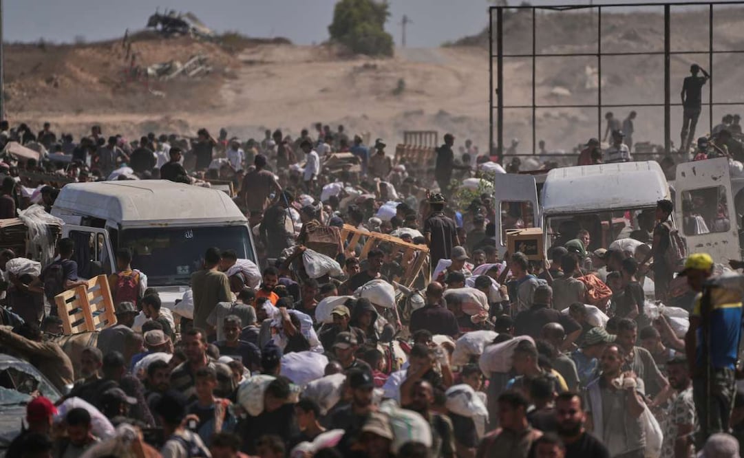 Palestinos llevan paquetes de ayuda humanitaria cerca de un centro de distribución de la Fundación Humanitaria de Gaza, operado por la organización respaldada por Estados Unidos, en Netzarim, en el centro de la Franja de Gaza, el lunes 4 de agosto de 2025. Foto: AP