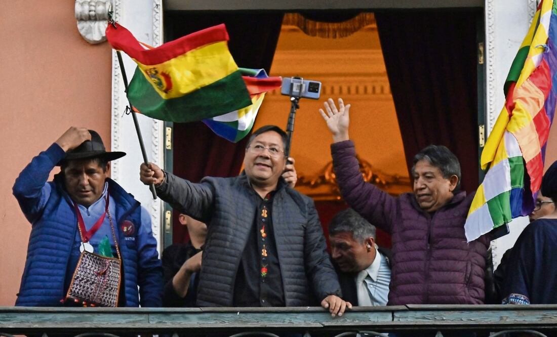 El presidente boliviano Luis Arce ondea una bandera de su país en el balcón del Palacio de Gobierno en La Paz, tras el movimiento militar. Foto: de Aizar Raldes. AFP