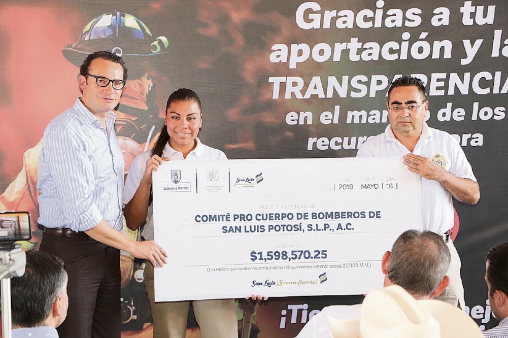 El alcalde de San Luis Potosí, Xavier Nava (izq), durante la entrega de más de millón y medio de pesos a bomberos, como parte de los recursos rescatados.