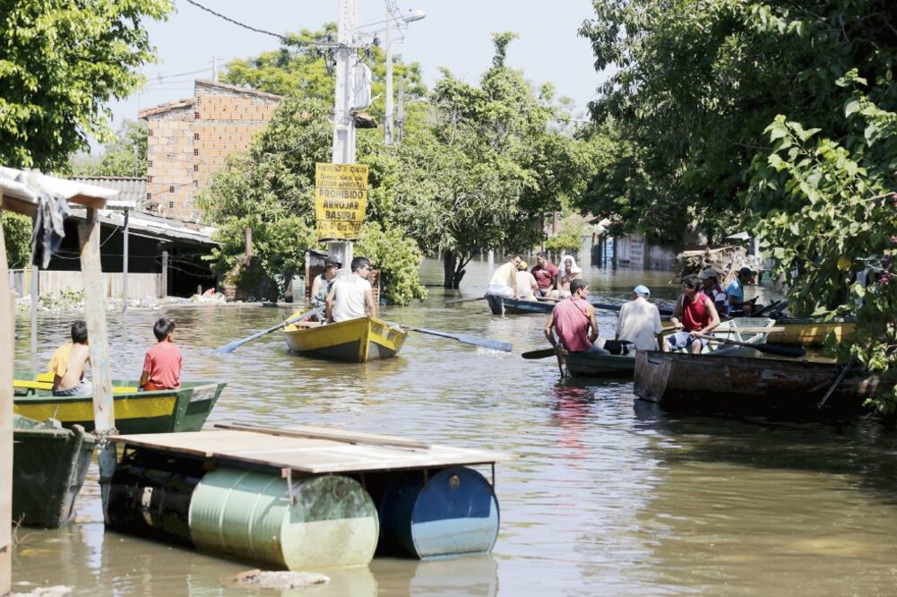 Residentes se trasladan en botes por los barrios inundados en Asunción. La crecida del río Paraguay ha afectado a miles de personas, que se han quedado sin hogar (JORGE ADORNO. REUTERS)