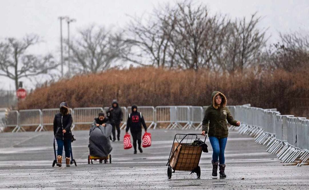 Personas caminan hacia un refugio para migrantes en el aeródromo Floyd Bennett Field de Brooklyn, en la ciudad de Nueva York. Foto: Spencer Platt / AFP