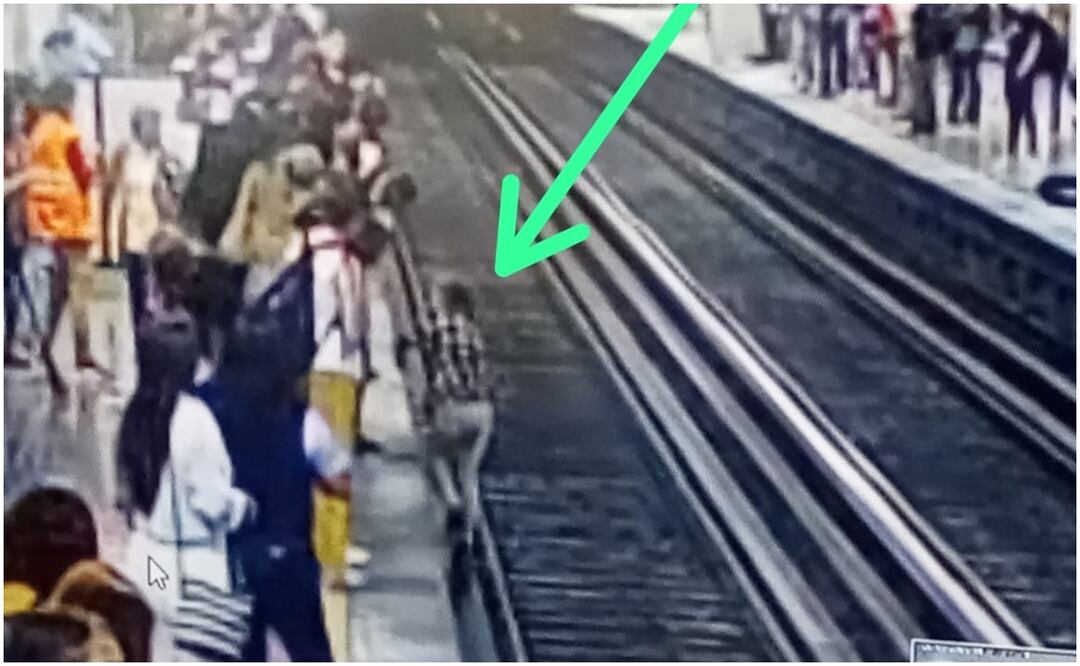 En imágenes que circulan en redes sociales se muestra que una mujer vestida con camisa de cuadros y pantalón con aparente color gris intenta bajar a las vías para recuperar su celular. Foto: Tomada de X, antes Twitter