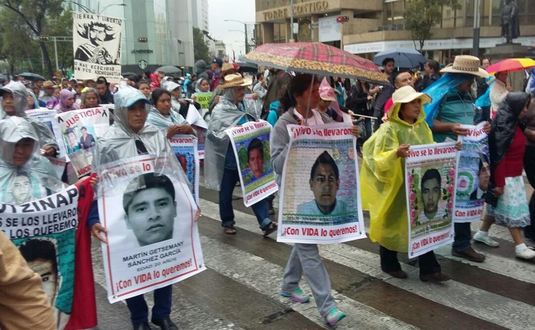 Padres de los 43 marchan, pese a lluvia