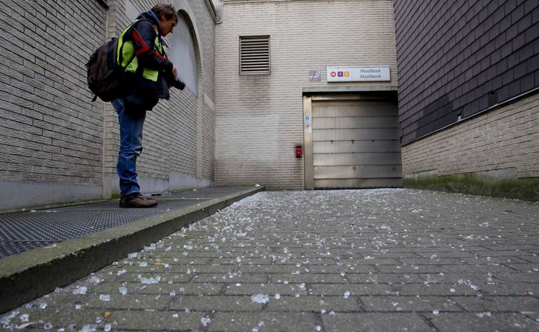 Un periodista toma fotografías de vidirios cerca de la entrada de la estación de metro Maalbeek, uno de los sitios en donde ocurrieron los atentados. Foto: Xinhua