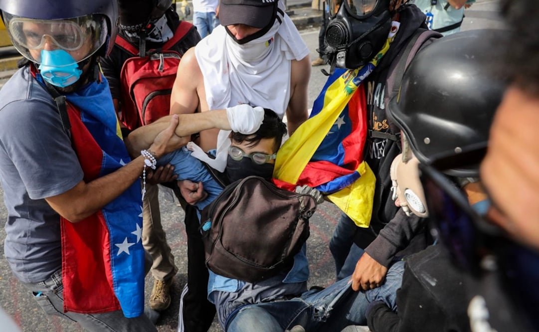 Un grupo de manifestantes auxilia a un joven de 22 años, luego de recibir un disparo de un miembro de la Guardia Nacional Bolivariana (Foto: EFE)