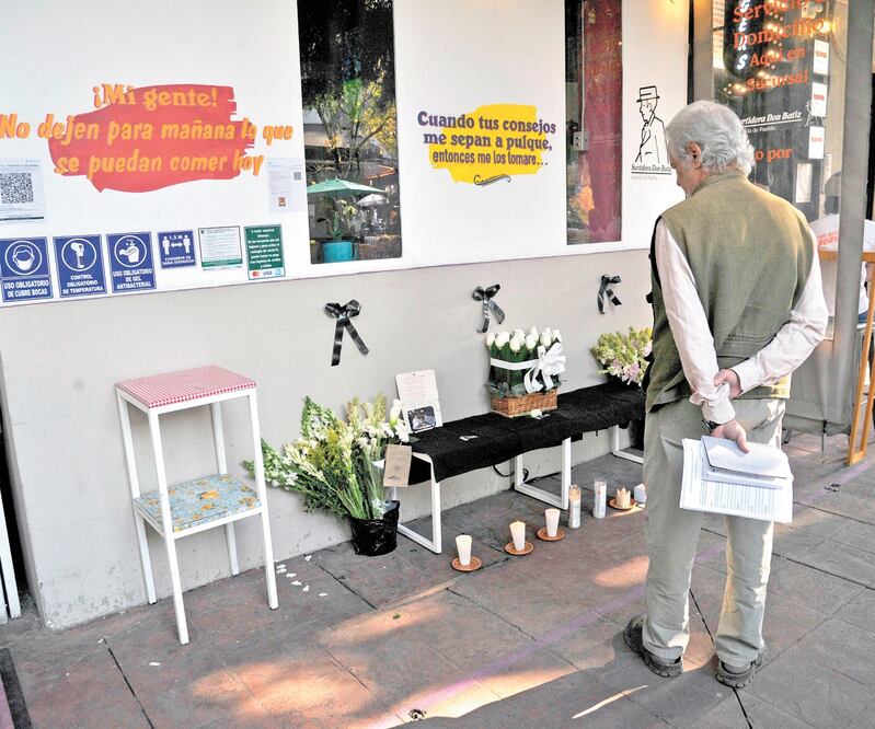 Un hombre observa el altar que empleados del restaura nte del empresario Baptiste Jacq ues Daniel instalaron al enterarse de su muerte. CLAUDIO CRUZ. AFP