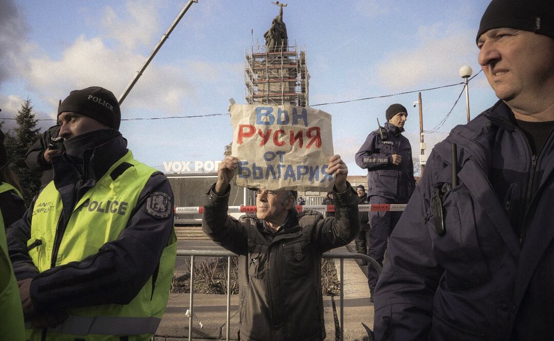 Un manifestante sostiene un cartel que dice "Rusia fuera de Bulgaria" mientras se manifiesta rodeado de policías durante el proceso de desmantelamiento del monumento del ejército soviético en Sofía, el martes 12 de diciembre de 2023.Foto: AP/Valentina Petrova.