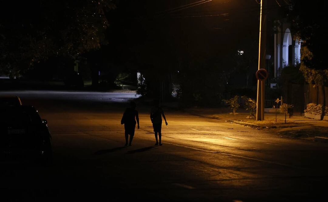 Personas caminan por una calle con poca iluminación el 17 de mayo de 2024 en La Habana. Foto: EFE
