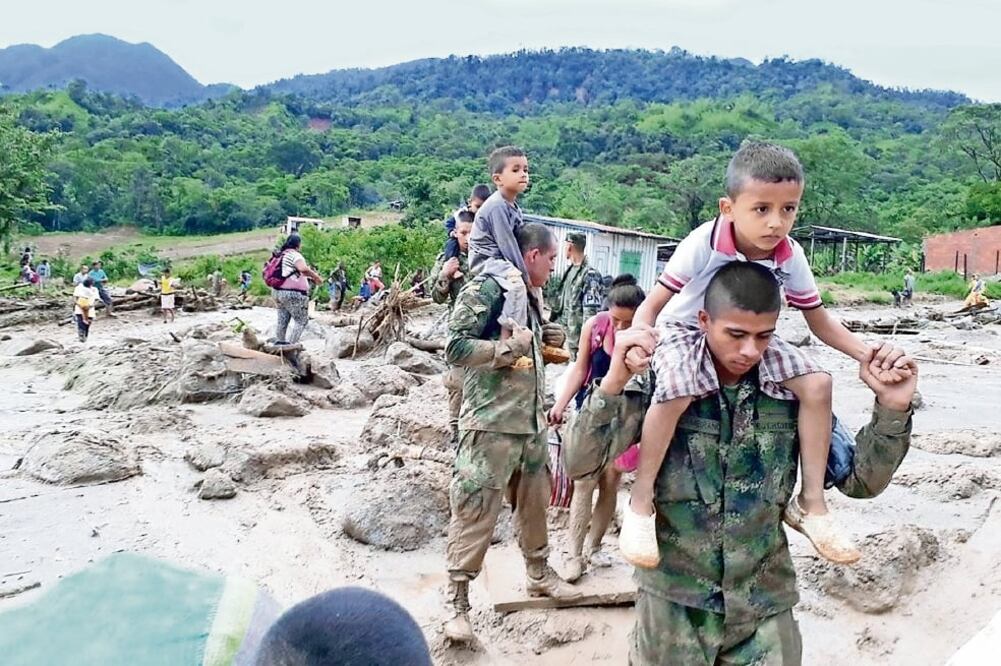 Decenas de militares y policías ayudaron ayer en Mocoa a reubicar a los damnificados y voluntarios de la Cruz Roja organizaron la entrega de la ayuda humanitaria (EFE)