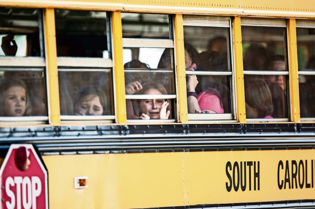Estudiantes de la escuela primaria Townville son trasladados a la iglesia bautista Oakdale, tras el tiroteo que dejó dos niños y una maestra heridos. El agresor, cuya motivación se desconoce, está detenido (KATIE MCLEAN. AP)
