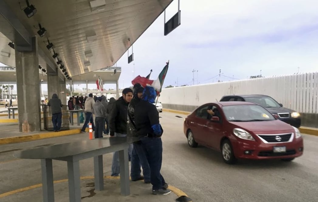 Protesters in Tijuana, Mexico, wave through motorists at the Otay Mesa Port of Entry with San Diego, Calif., after Mexican authorities abandoned their posts on Sunday, Jan. 22, 2017. (AP Photo/Elliot Spagat)