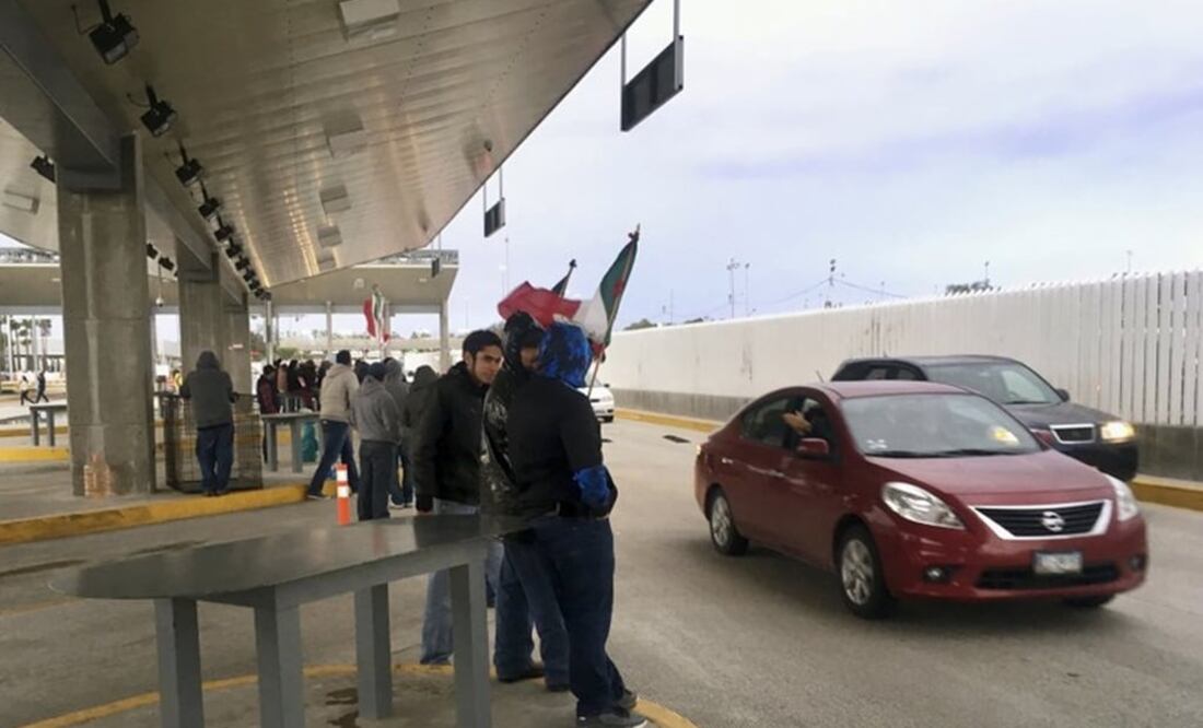 Protesters in Tijuana, Mexico, wave through motorists at the Otay Mesa Port of Entry with San Diego, Calif., after Mexican authorities abandoned their posts on Sunday, Jan. 22, 2017. (AP Photo/Elliot Spagat)