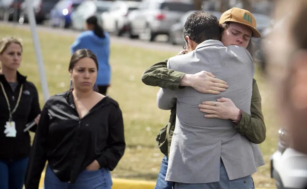 Un alumno, a la derecha, abraza a un padre al reunirse después de un tiroteo escolar en la escuela East High School. Foto: AP