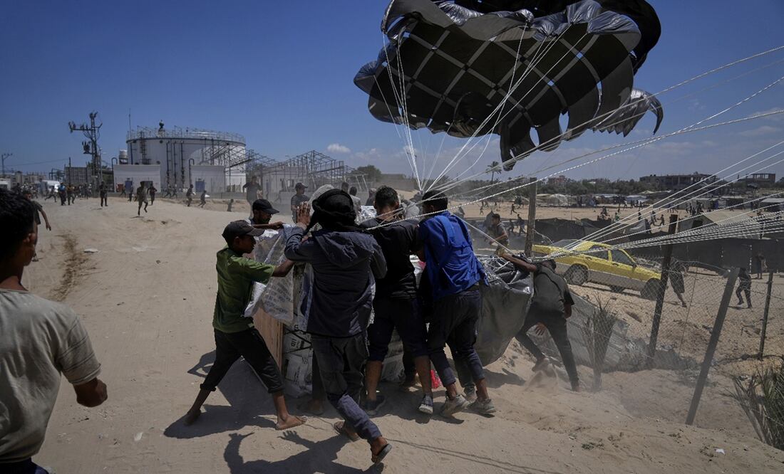 Palestinos se abalanzan sobre la ayuda humanitaria lanzada en paracaídas sobre Deir al-Balah, en el centro de la Franja de Gaza, el martes 5 de agosto de 2025. Foto: AP