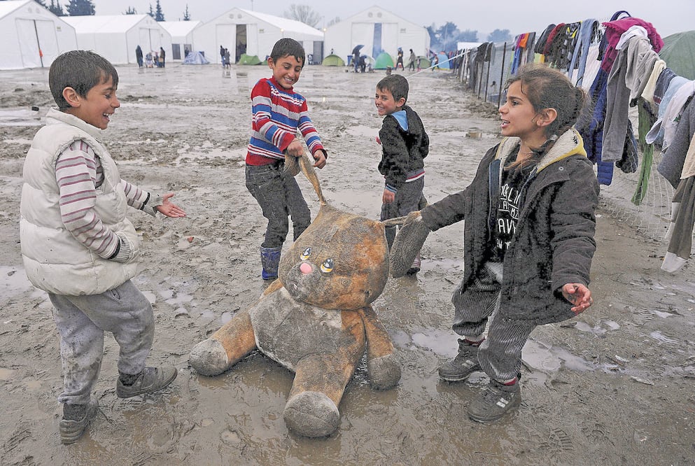 Refugiados juegan con un conejo de peluche, en un campamento para refugiados cerca de la localidad griega de Idomeni. (REUTERS)
