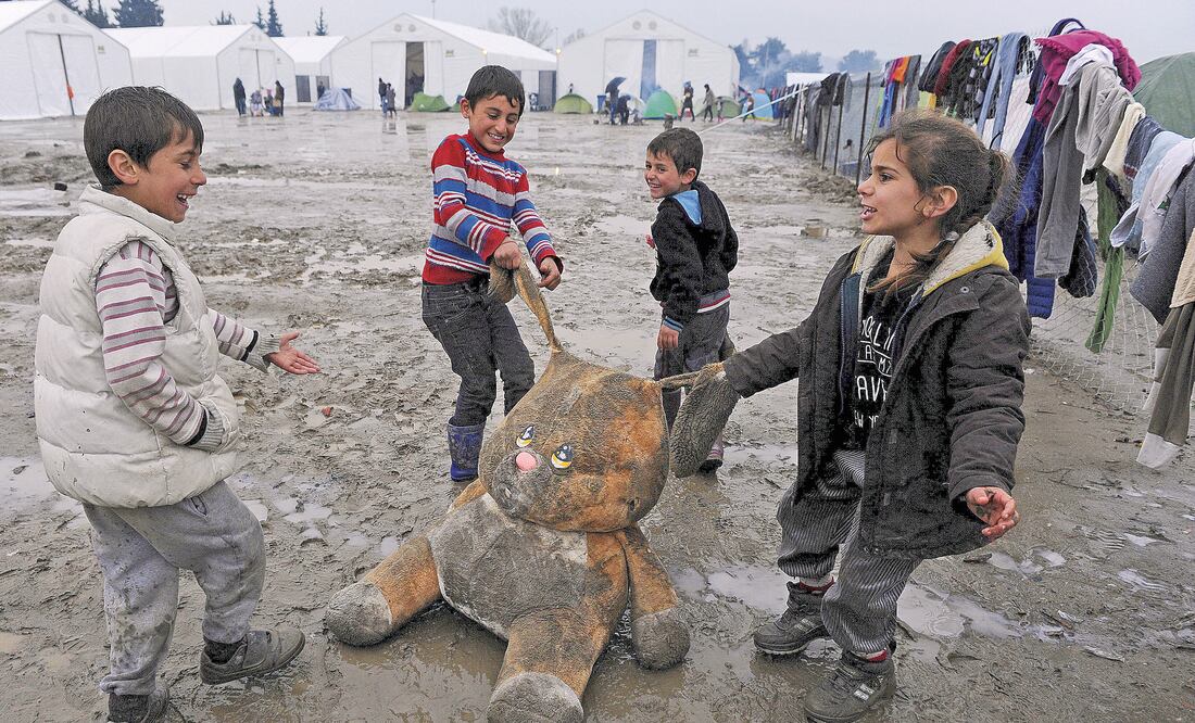 Refugiados juegan con un conejo de peluche, en un campamento para refugiados cerca de la localidad griega de Idomeni. (REUTERS)