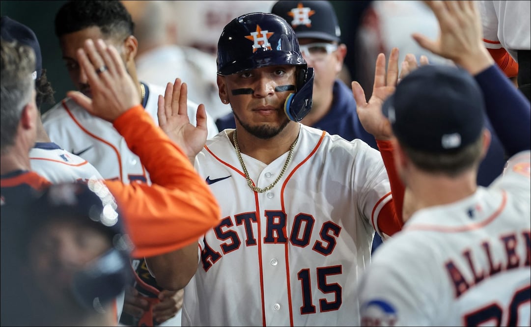 Isaac Paredes es felicitado en el dougout de los Astros tras su imparable productor de dos carreras. FOTO: AFP