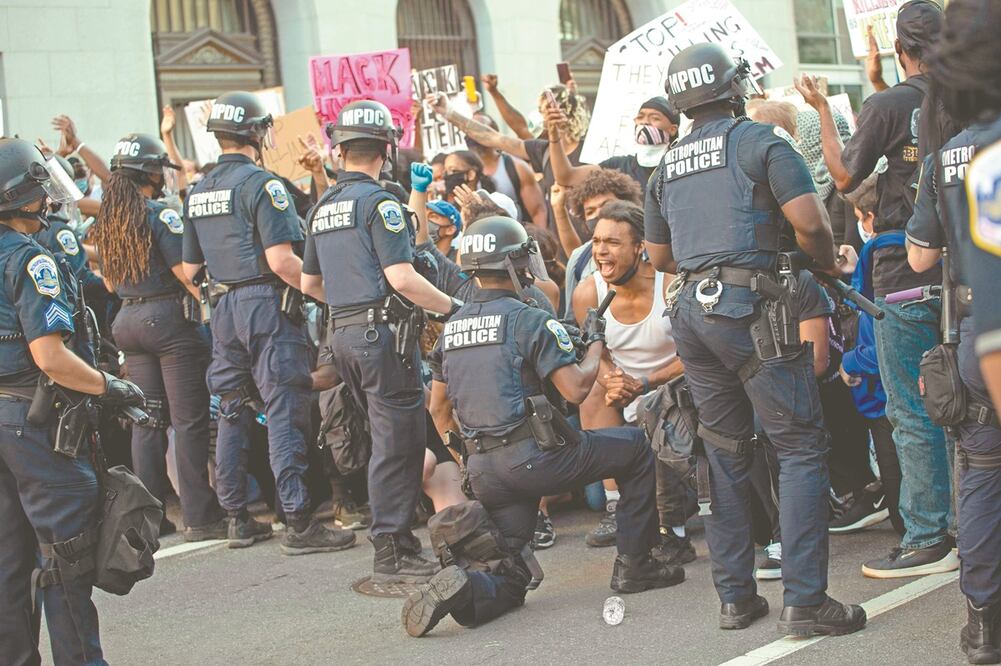 En la protesta de ayer en Washington D.C., la gente se conmovió ante el gesto simbólico de un policía, quien se arrodilló frente a los manifestantes para expresar su repudio a la opresión racial. Foto: ROBERTO SCHMIDT. AFP