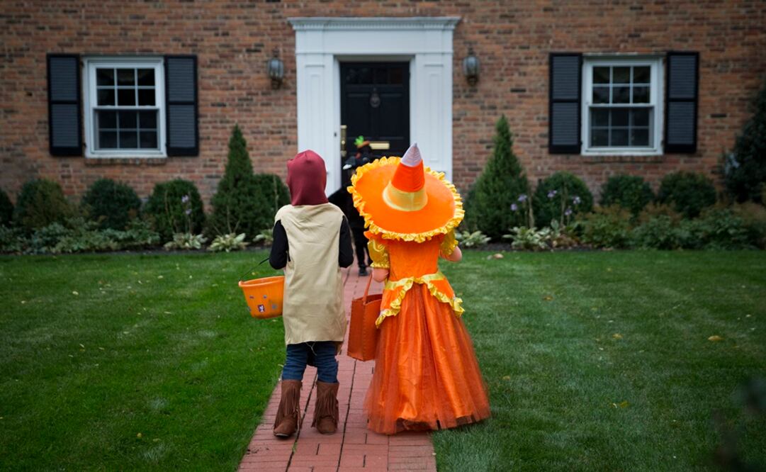 Kids dressed in costumes wait for candy while trick or treating during Halloween in Port Washington, New York - Photo: Shannon Stapleton/REUTERS