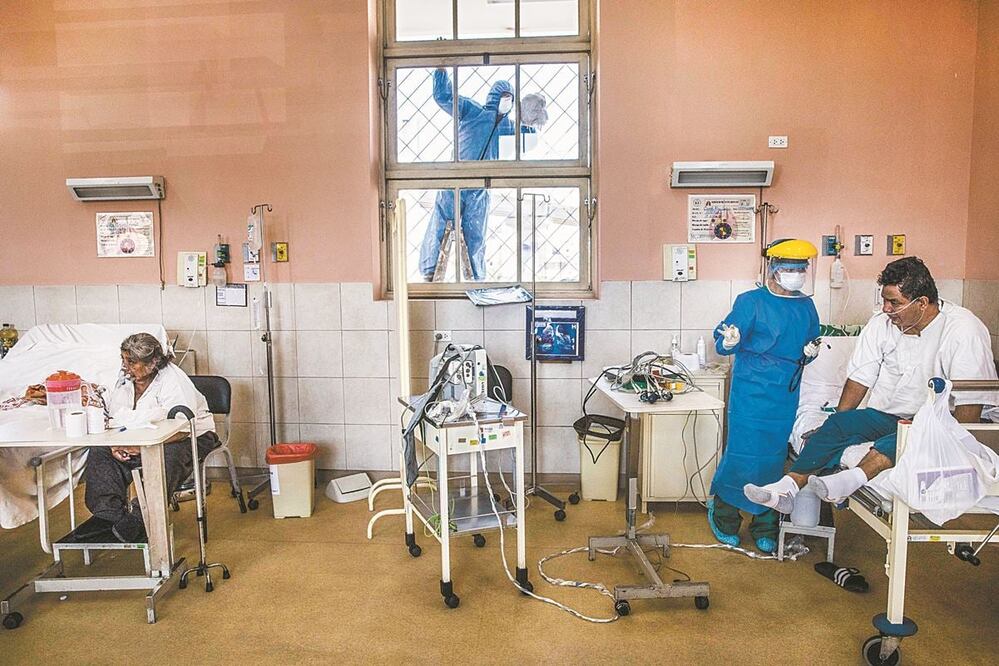 Empleado sanitario ayuda a pacientes con coronavirus en el hospital 2 de Mayo, en Lima, Perú. RODRIGO ABD. AP