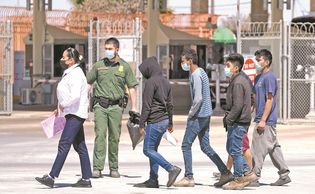 Migrantes, que fueron detenidos por las autoridades fronterizas, en el puente internacional McAllen- Hidalgo. Foto: Julio Cortez. AP